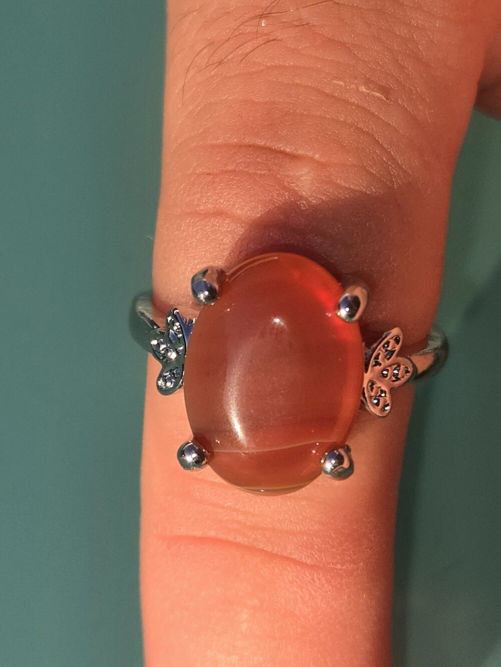Orange gemstone ring with butterfly design